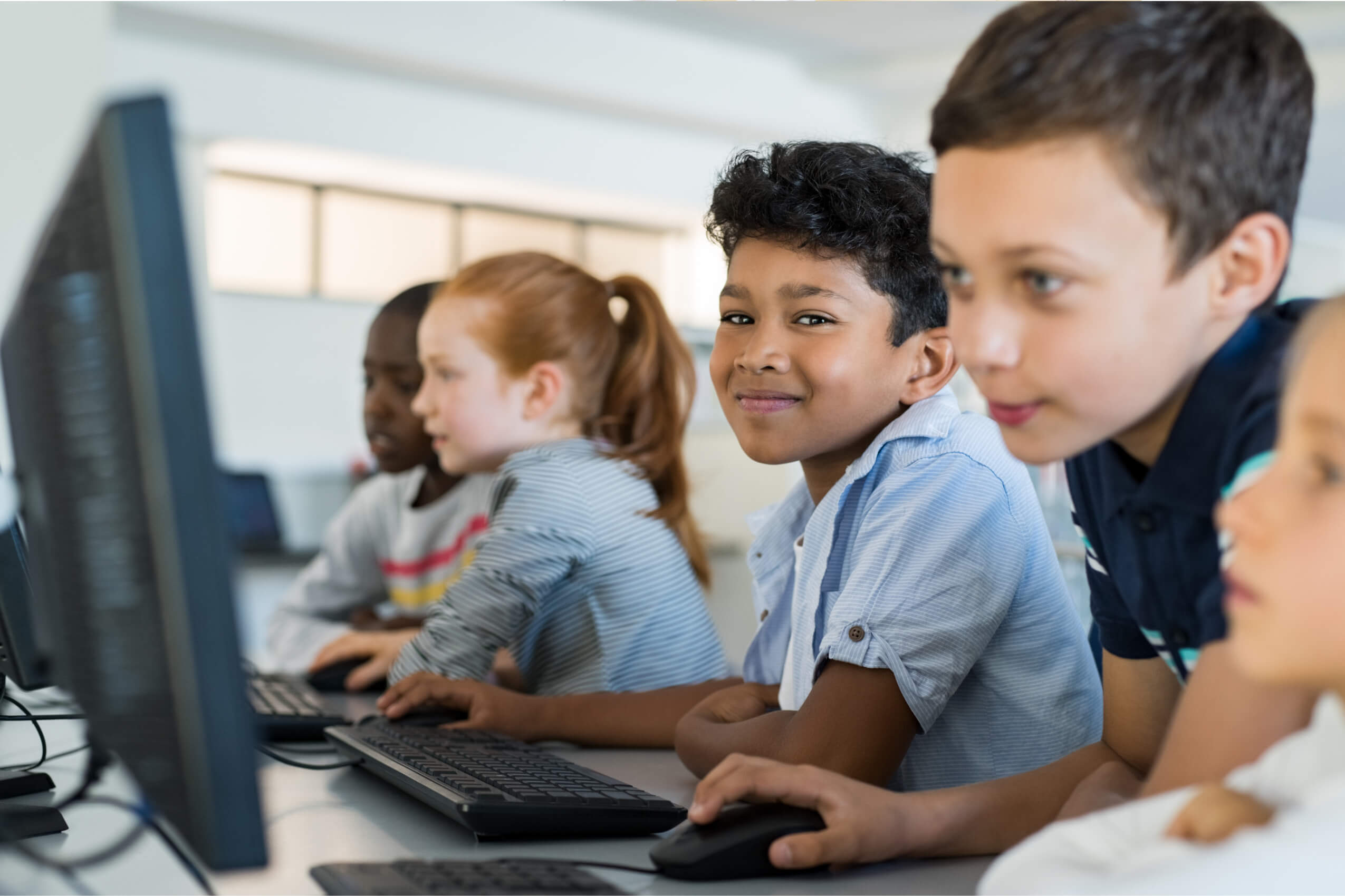 Young students working on desktop computers together